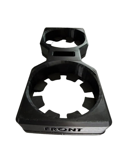 A black plastic cup holder insert for a vehicle, shown on a plain off-white background. The front of the insert is labeled 'FRONT' and features a textured, rugged design with circular cutouts.