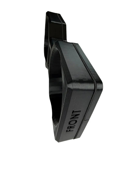 A black 3D-printed mechanical component or bracket with the word 'FRONT' printed vertically on its side, photographed on a light gray background.